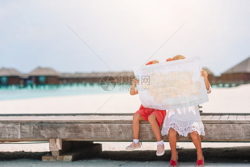 姐带大的小女孩在海滩上选择下一站带大的小女孩在热带海滩度假的小可爱女孩蓝色的水图片