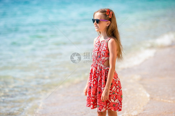 沙滩上紧贴女孩在海边背景暑假的海滩上可爱小姑娘在海滩上过暑假夏天俏皮堂图片