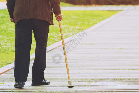 男公民老头手牵走路棍棒紧贴近身步行背景