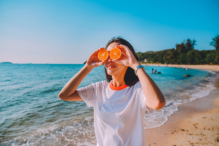 海滩沙滨背景中持有橙色切片的妇女夏季假日古年背景健康户外图片