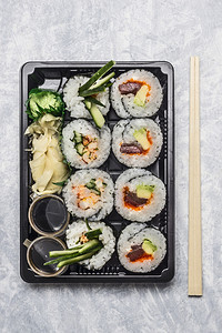 晚餐黑色运输箱或便当盒中的寿司菜单灰色背景顶视图关闭东小吃图片