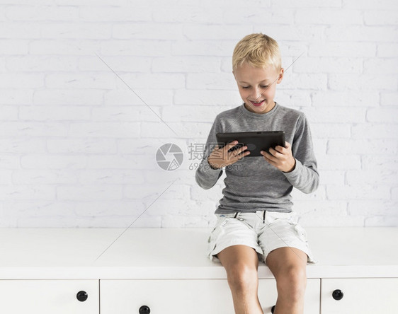 冬天房间可爱的小男孩与平板电脑玩得开心男生图片