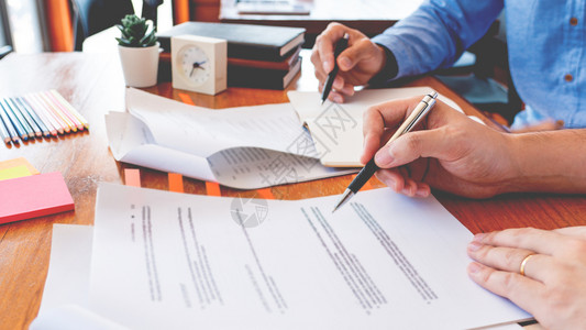 大学生在教室的桌子上一起教学校作业和解释问题决方案学习和阅读背景