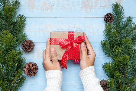 持有礼品盒圣诞装饰和木背景的松树枝节日概念准备新年快乐和Xmas假日顶端风景等礼物盒的妇女拳击新天图片