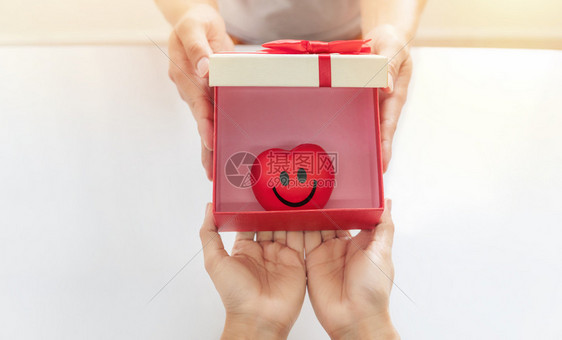在白背景的生日圣诞节和新年时提供礼物盒和红橡胶笑容的亚洲男人和女在屋内为生日圣诞和白背景的新年举行成人给予图片