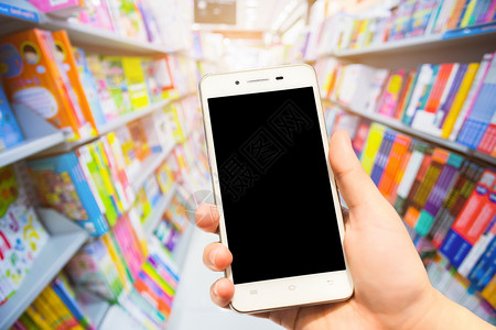 排图书馆女在BookehBookeh杂志上使用智能手机模糊图像摘要背景从超市的书架到杂志快乐图片