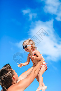 快乐的父亲和他可爱小女儿在沙滩上玩图片