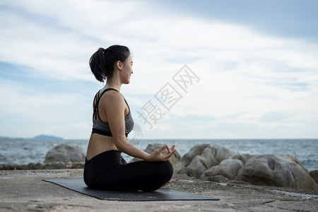 在超现实日落的海边健康概念和锻炼中在超现实日落期间从事瑜伽的妇女士海滩早晨图片