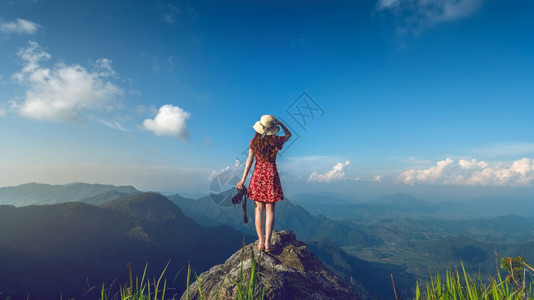 照片景观女手握着相机站在自然中的岩石顶端旅行概念的温和音调谷图片
