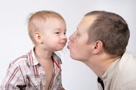 幸福爸亲吻他的小儿子在白色背景的人肖像乐趣图片