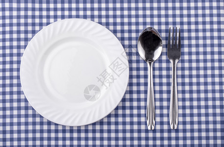 蓝色格子背景上带银器的盘子晚餐现代午图片