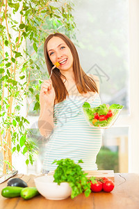 胃莴苣笑着的孕妇吃沙拉照片保持图片