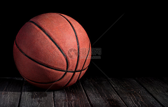 运动竞技木地板上的篮球黑色背景的比赛图片