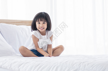 年轻的人类一个亚洲可爱的小女孩醒来坐在床上清早晨梦图片