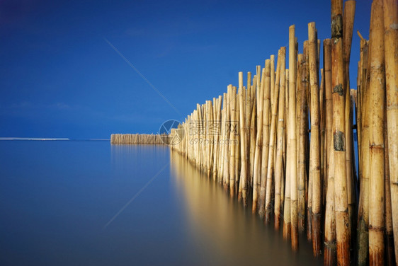 竹栅栏保护沙滩免受海浪影响图片
