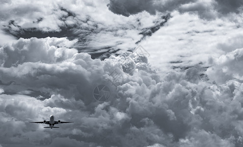 灰色的乘客空中飞机在黑暗天空和白毛云上飞行商业航空公司载有梦想目的地概念目地航空商业危机概念航空商业危机概念暑假飞行未能成功图片