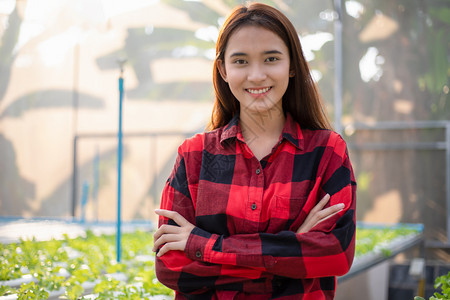 农业年轻的亚洲女农民在温室水养有机植物运动企业家有机蔬菜农场和健康食品概念中微笑的亚洲女农民保持图片