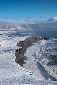 冰岛Dyrholaey角海岸景观的全图象在冬季与积雪覆盖海岸线的冰岛天空风景自然图片