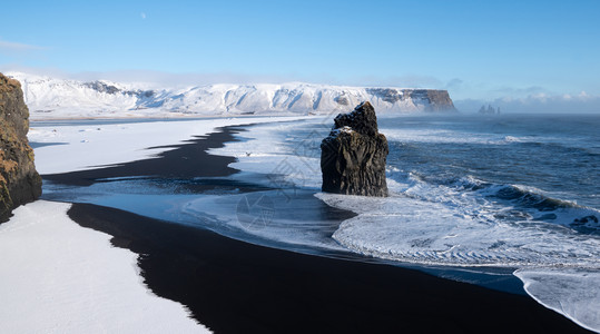 海滨白雪皑水冰岛Dyrholaey角海岸景观的全图象在冬季与积雪覆盖海岸线的冰岛图片