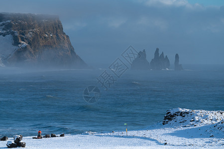 灰蒙风景优美冰岛Dyrholaey角海岸景观的全图象在冬季与积雪覆盖海岸线的冰岛路德维希图片