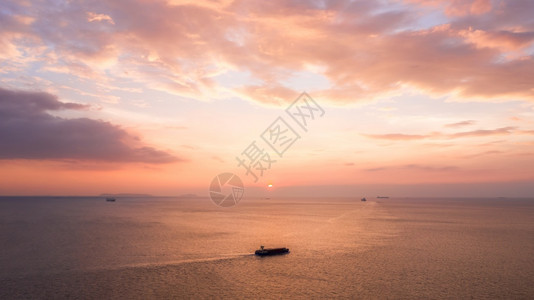 高的无人机自然海景和小型集装箱船在深夜粉色天空背景下海上航行的景和小型集装箱船图片