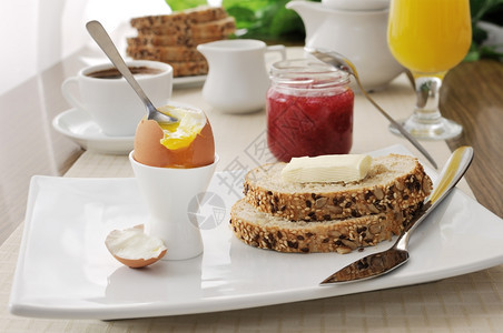 整理茶点乐趣软煮鸡蛋加片燕麦面包和黄油早餐图片