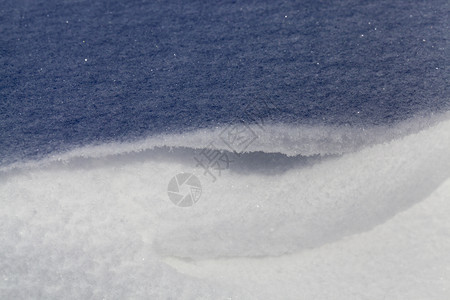 经过雪花下着美丽的部分是阳光照亮的第二部分是在阴暗中冬季寒冷的天气和风雪表面结构中第二部分是在寒冷的气候和风雪表面结构中冻图片