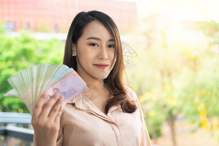 肖像纸币幸福快乐的亚洲女商人微笑和持有钞票商业成功稳定交易和金融概念欢笑和持有钞票图片