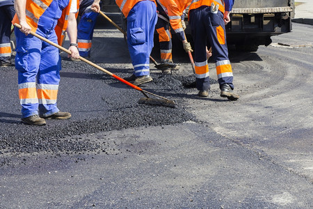 领班在公路街道修复工程期间在Aphaltingpaveer机器上工作的人建造振动器图片