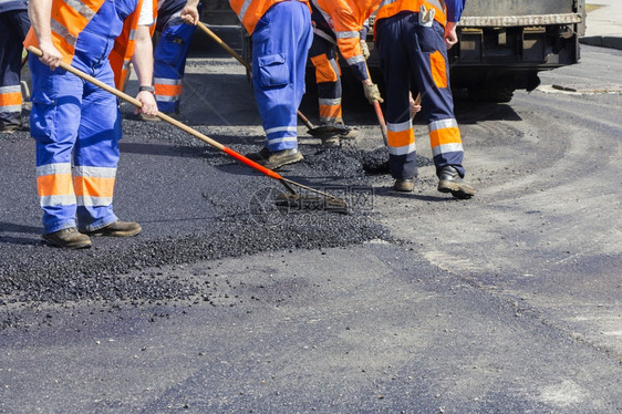 领班在公路街道修复工程期间在Aphaltingpaveer机器上工作的人建造振动器图片