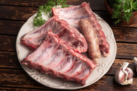 香料新鲜猪肉肋骨和木桌上的牛排香肠准备在西班牙楚拉斯科烧烤中煮熟木制的晚餐图片