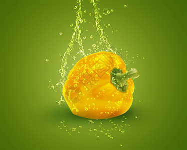 清除果汁绿色背景上喷水的新鲜黄色铃辣椒气泡图片