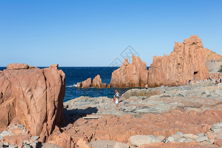 巨石礁海浪意大利Arbatax海附近的Sardinia海岸线典型红岩和克里夫斯以及旅游者图片