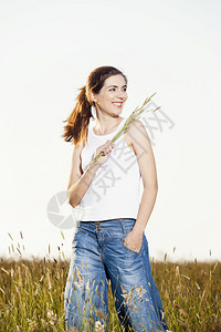 外出画像一个美丽的女人在夏日拿着花朵的外门肖像农村漂亮的景观图片
