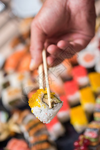 人肉手握着寿司用筷子顶视线营养保持绿色图片