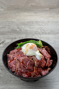 盘子超过秋冬生牛肉和小鸡蛋在木制桌上吃大米日本的奢华食品概念桌子图片