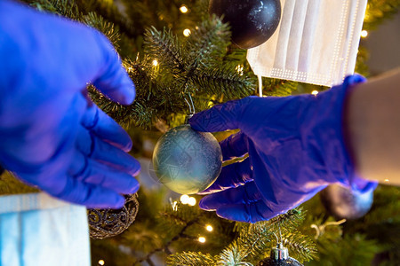 时期封锁用Covid19防护安全手套冠状概念和圣诞假期特写装饰美丽圣诞树的人用防护安全手套冠状概念和圣诞假期装饰美丽圣诞树的人药图片