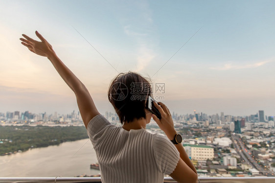 女孩站在阳台与城市对BangkokCopy空间选择焦点的视线相对立年轻女子背面自由年轻的图片