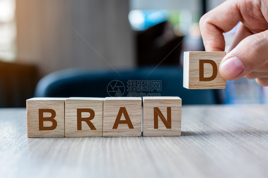 目标帕努瓦桌子商人手握木制立方块布兰德公司在表背景营销广告和产品开发概念上写有BRAND公司字图片