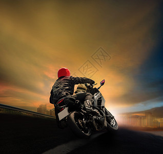 男子骑摩托车在沥青高速公路上对抗日落天空追踪骑自行车飞机图片