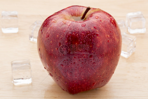 蔬菜营养食物木桌上有水滴的成熟红苹果特写木桌上有水滴的成熟红苹果图片