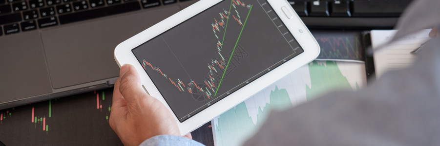 分析金融数据图表和为投资目的屏幕上报告以用于股票市场交易图的证券市场交易图分析金融数据图表和报告办公室利润全球的图片