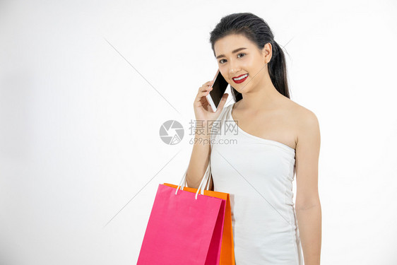 亚洲买美丽的裔女与美丽孩拿着购物袋使用智能手机在网上用信卡购物时笑着微un图片