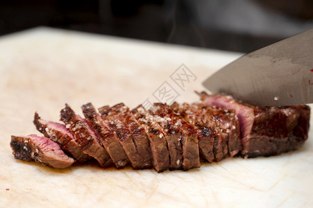 大理石纹厨师在商业房的板上切多汁牛排高品质摄影师在商业厨房的板上切多汁牛排肉职业图片