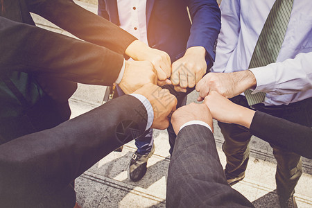 男交易商界人士在圈商业和团队合作概念中握手拳头公司的图片