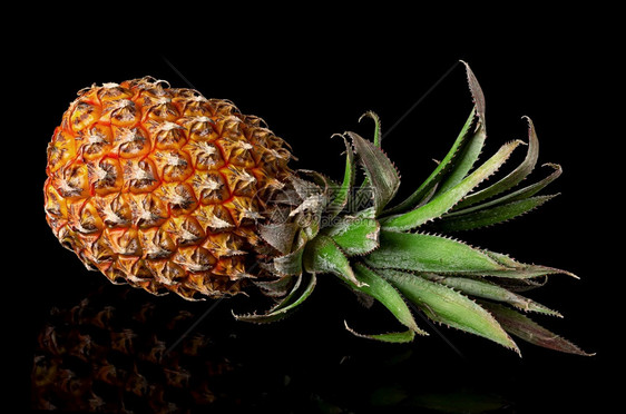 整只有反射的菠萝在黑色背景上隔绝整头菠萝在黑色面上隔绝了反射凤梨异国情调食物图片