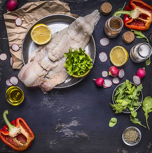 以黄油和季节的煎萝卜上生鳕鱼以深蓝色锈木本底面的胡椒和草药柠檬美味的新鲜晚餐图片