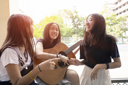 微笑一群亚裔青少年快乐情绪在现场弹着西班牙语吉他游戏组团体闲暇图片