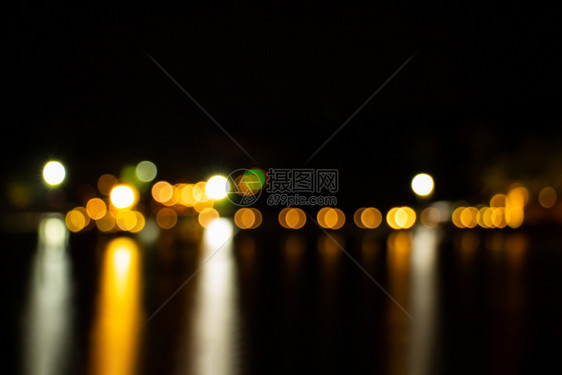 城市夜暮模糊明亮的浅金色bokeh反射海洋地表水抽象背景采取商业图片