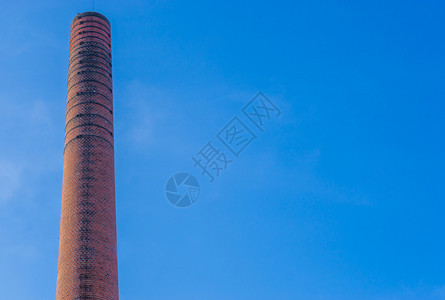 燃烧火历史古老的石头烟囱烧炉旧工厂建筑背景中的蓝天图片